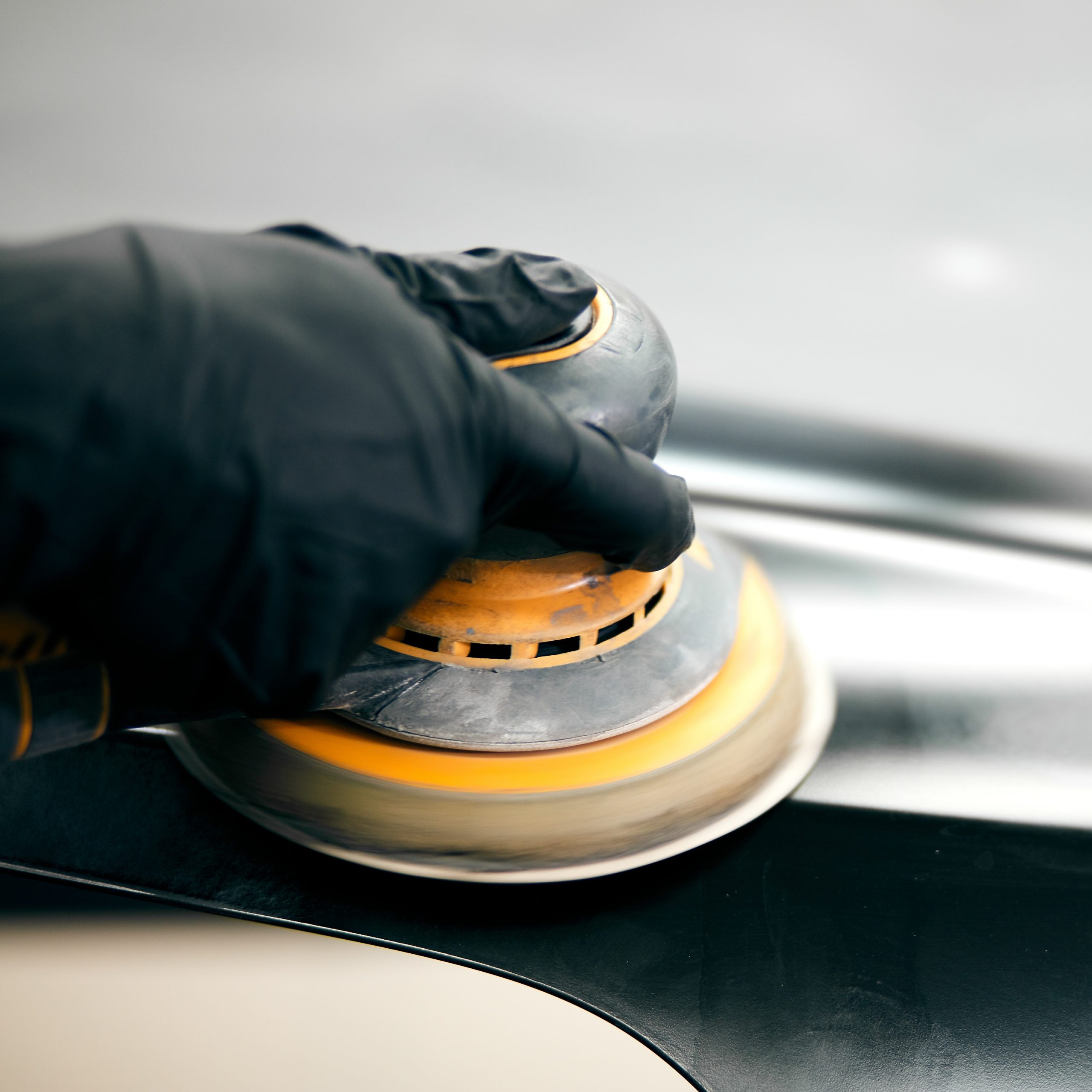 mechanic worker repairman sanding polishing car and preparing automobile for painting