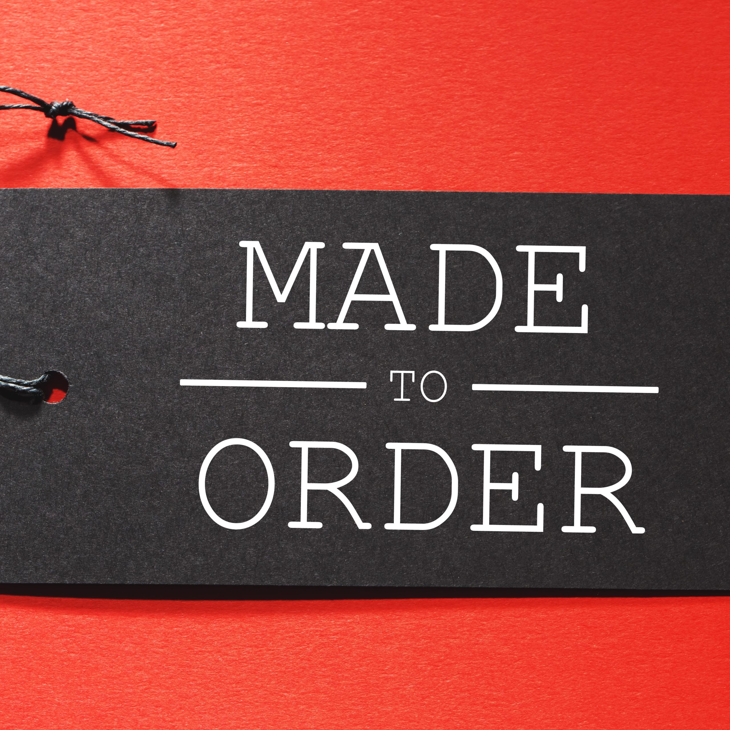 Made to Order text on a black tag on a red paper background